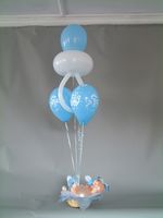 baby boy in basket with bouquet balloons